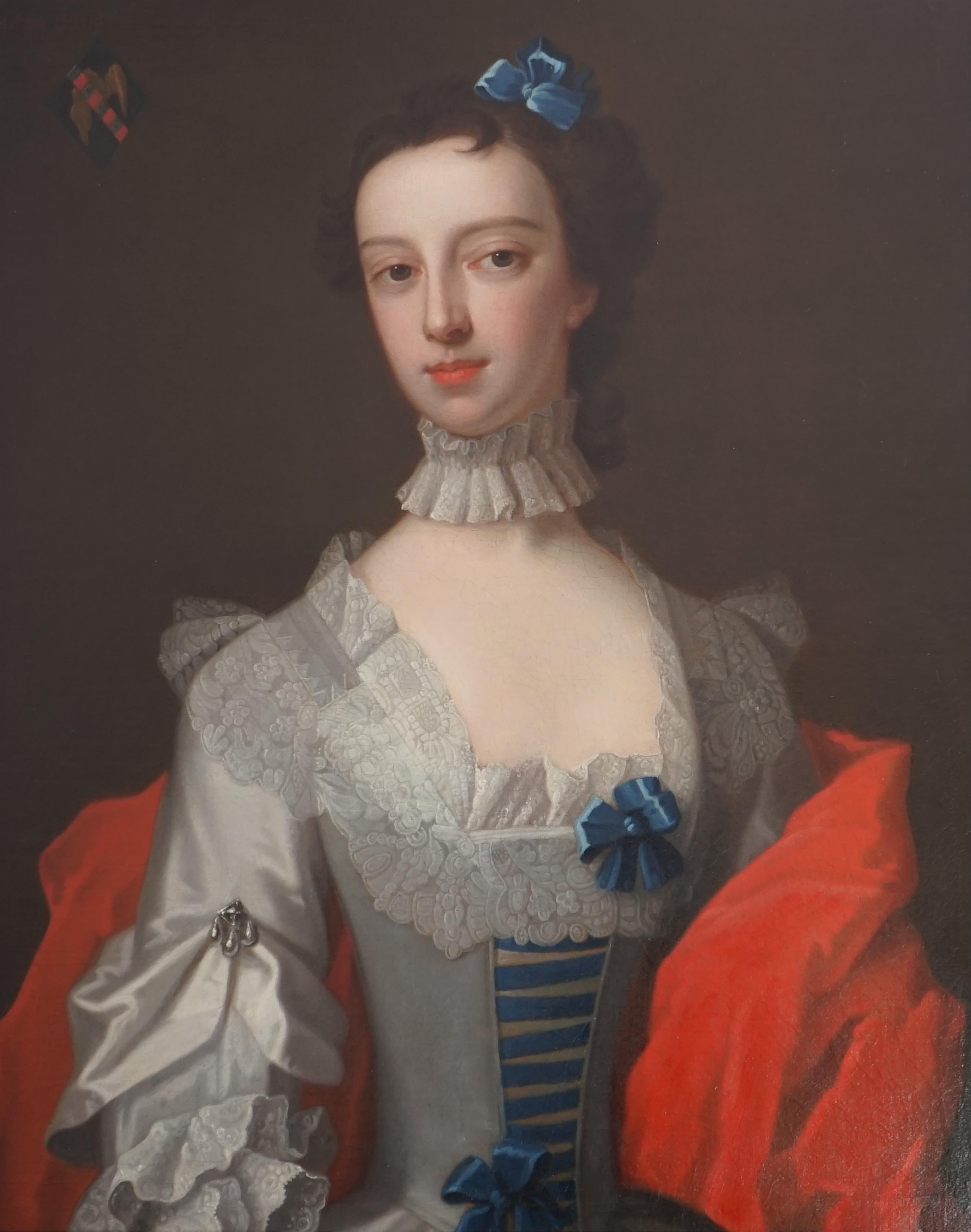 Attributed to Enock Seeman (c.1694-1745), Half length portrait of a lady with blue ribbon in her hair, elaborate lace collar and crimson robe, an armorial to the top left, oil on canvas, 74 x 62cm